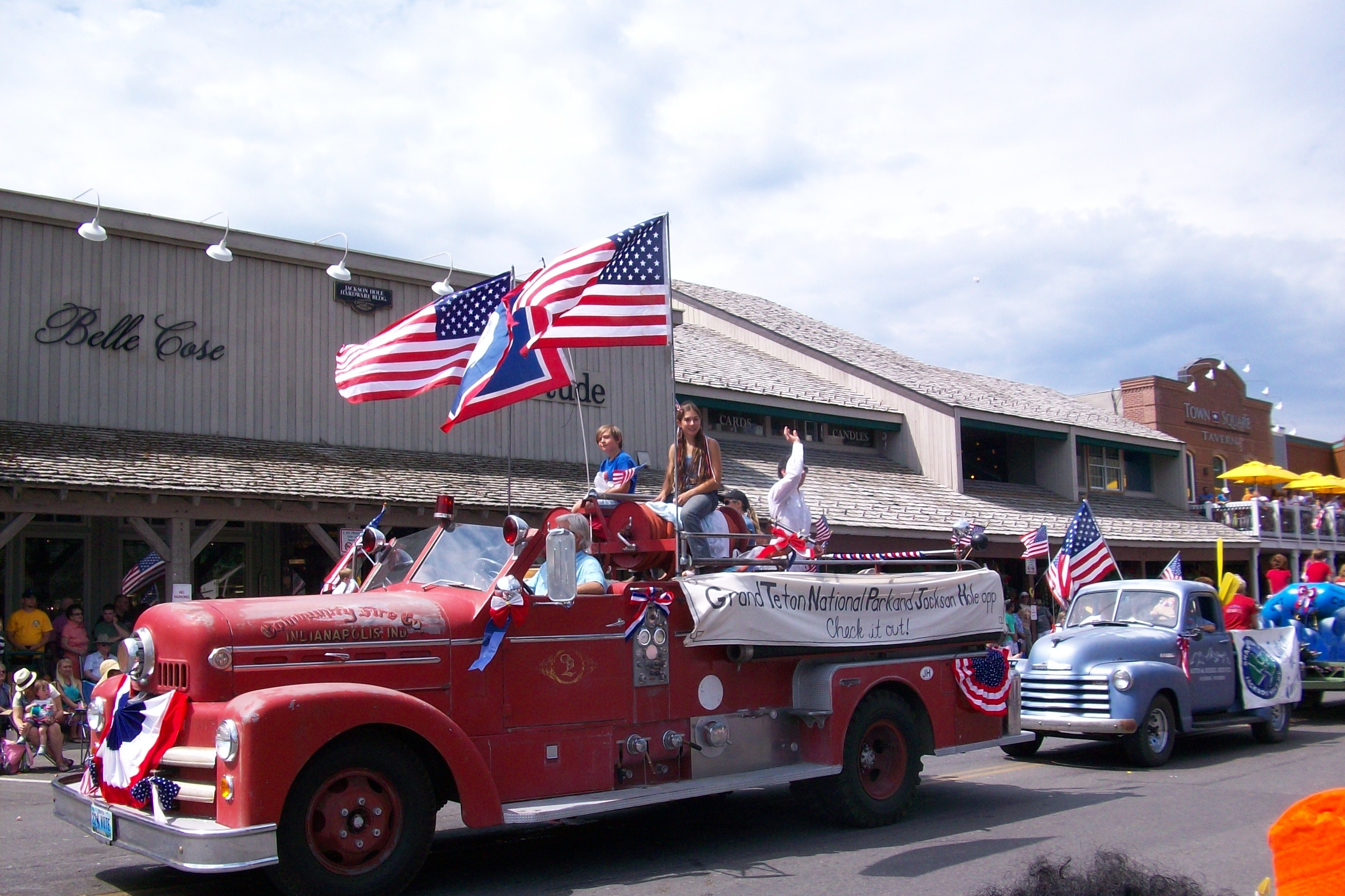 A vintage firetruck with American flags drives through downtown Jackson, WY, during the 4th of July Parade
